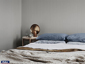 Neutral Grey painted board with textured blankets and blue pillows timber table and rose gold deco
